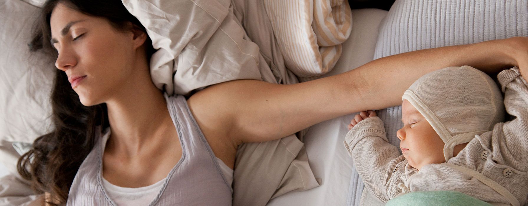 mujer y bebé tumbados en una cama dormidos