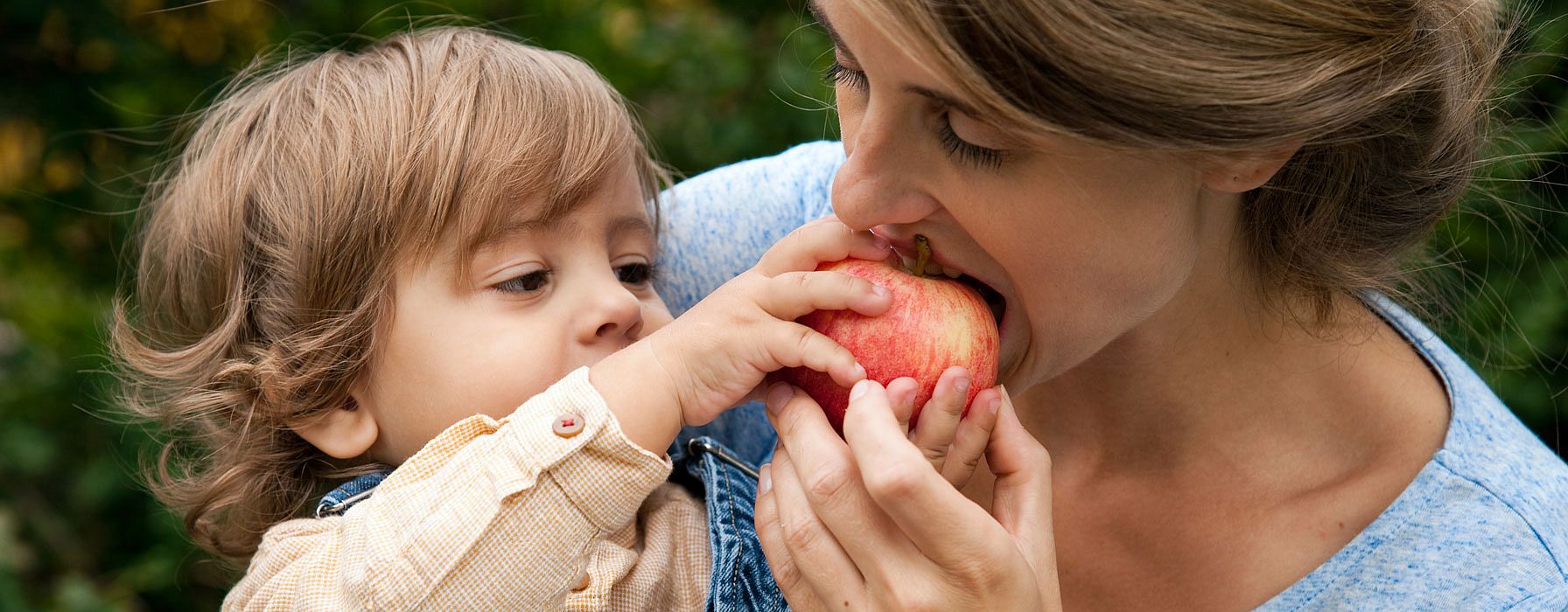 bebe le da de comer una manzana a su mama
