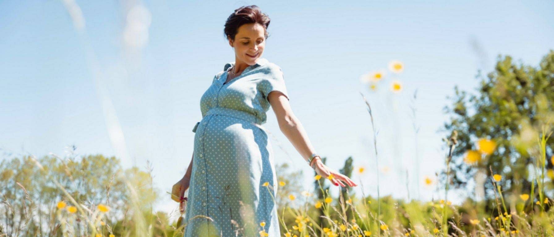 mujer embarazada feliz en el campo