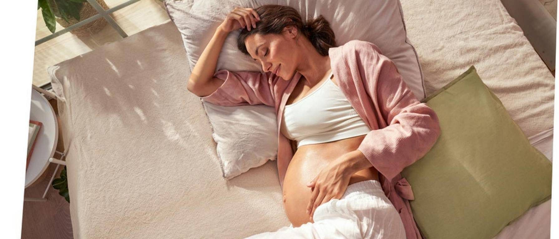 mujer embarazada tumbada en la cama
