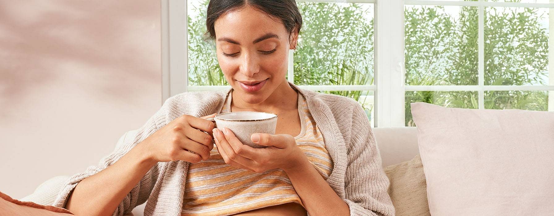 mujer embarazada con una taza en las manos