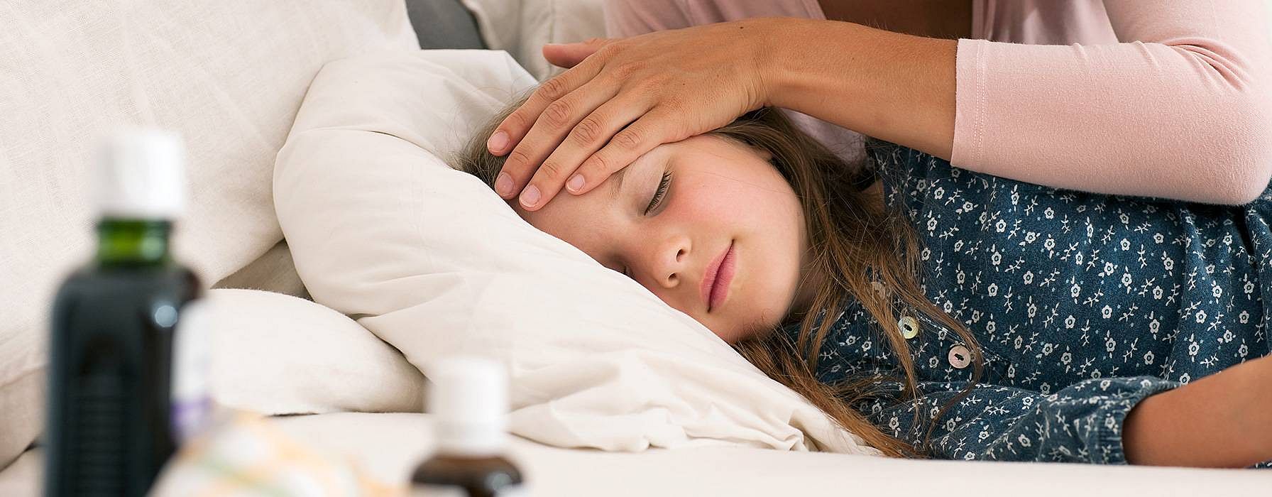 madre acaricia al niño enfermo.