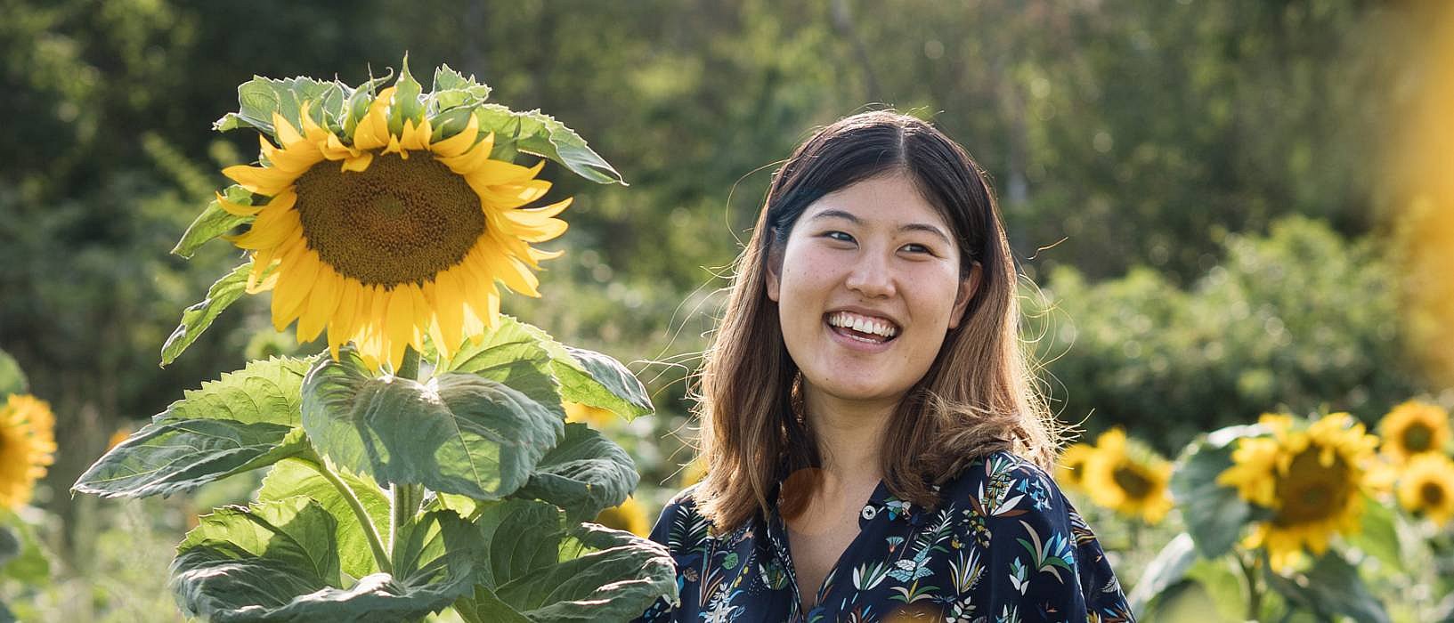 Mujer que ríe al lado de los girasoles