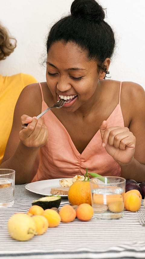 Woman sitting at a table and eating healthy food