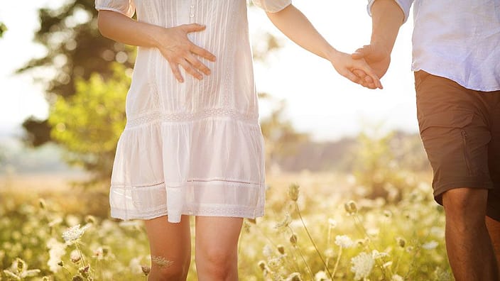pareja paseando agarrada de la mano en la naturaleza