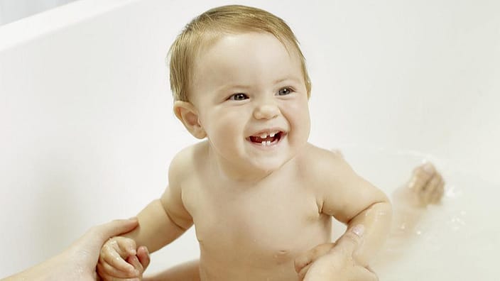 bebé en una bañera sonriendo
