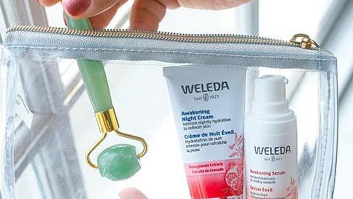 manos sujetando los productos de la gama reafirmante de granada y un rodillo facial de jade