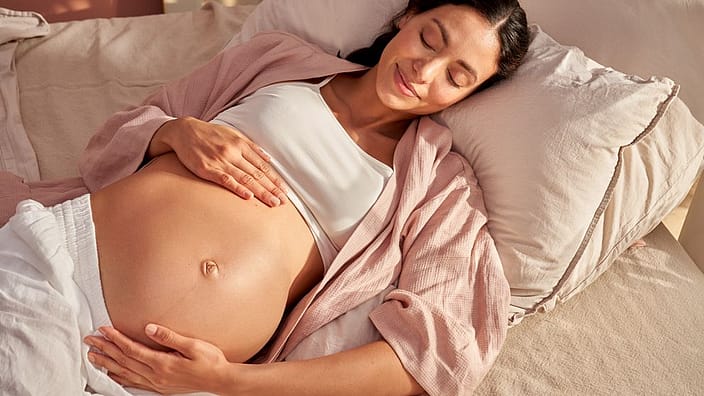 mujer embarazada tumbada en la cama