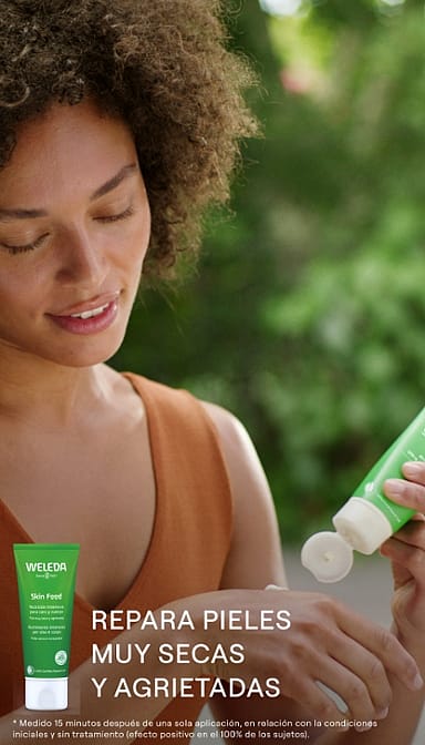 mujer aplicandose crema skin food de weleda en la mano