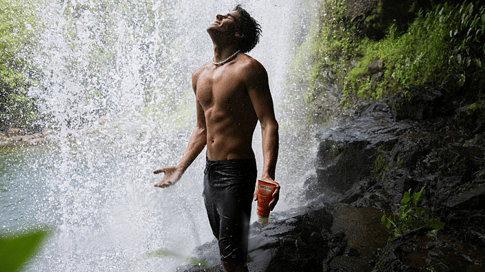 hombre en la naturaleza con cascada detras