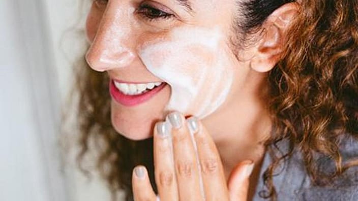 mujer haciendose limpieza facial