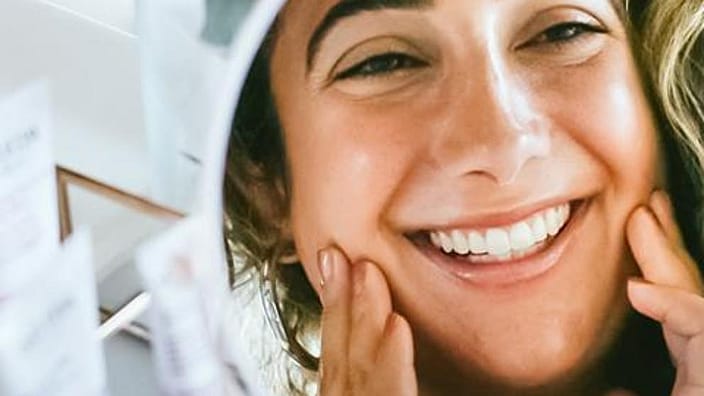 reflejo en un espejo de cara de mujer sonriendo