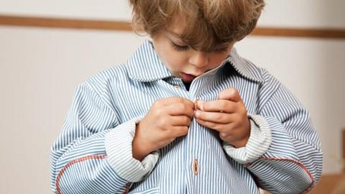niño poniendose ropa solo