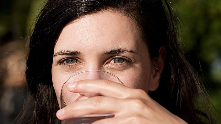 mujer bebiendo vaso de agua