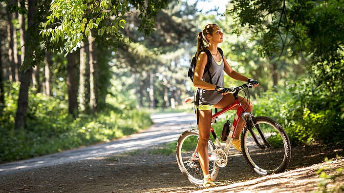mujer en bicicleta por la naturaleza