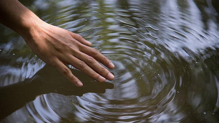 mano toca agua