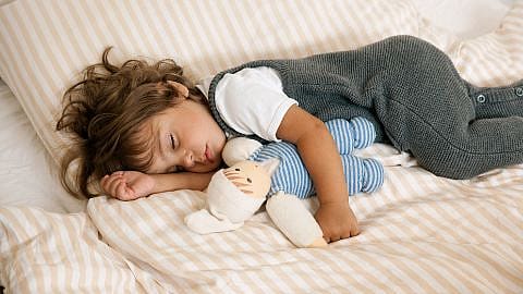niño durmiendo abrazado a su peluche