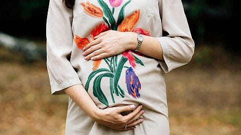 mujer embarazada tocandose la tripa para saber como esta colocado el bebe