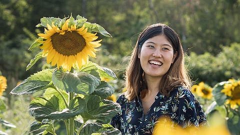 Mujer que ríe al lado de los girasoles