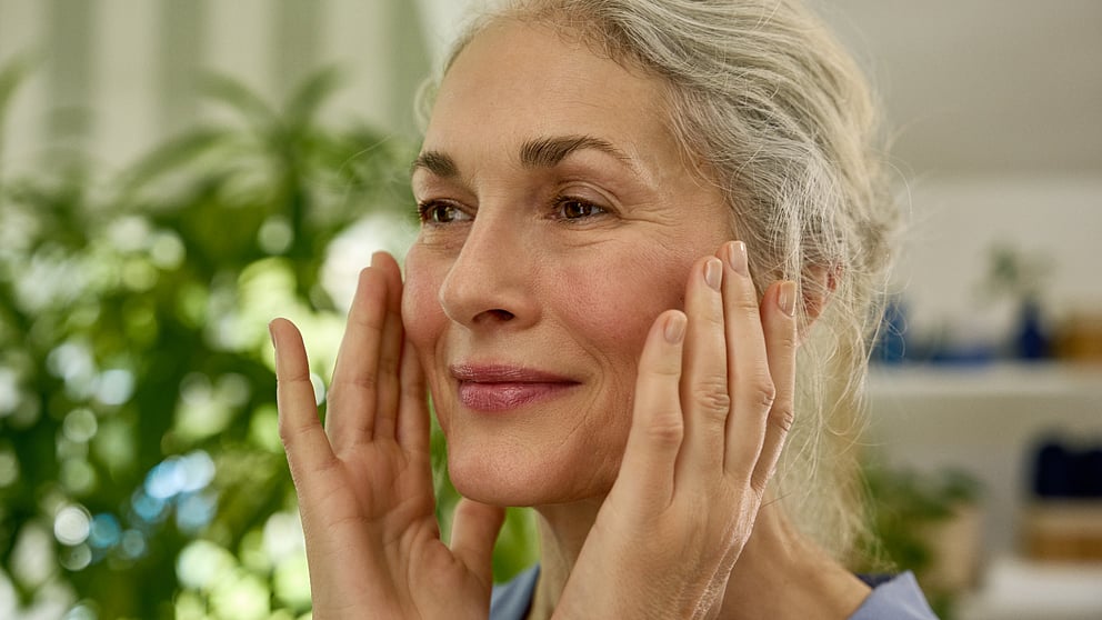 woman applying cream on face